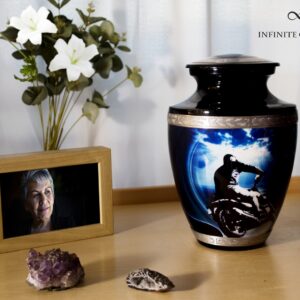 A black urn for ashes with a motorcycle driving to the sea with gold decorations
