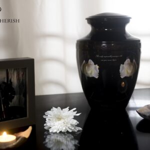 A black urn for ashes with a motorcycle driving to the sea with Black decorations