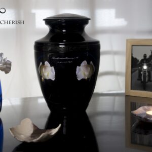 A black urn for ashes with a motorcycle driving to the sea with Black decorations